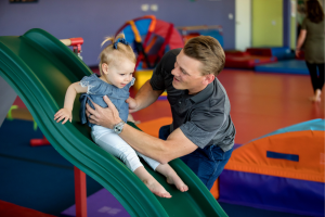 Young children participating in a movement-based developmental class, building confidence, coordination, communication, and social skills through guided play activities.